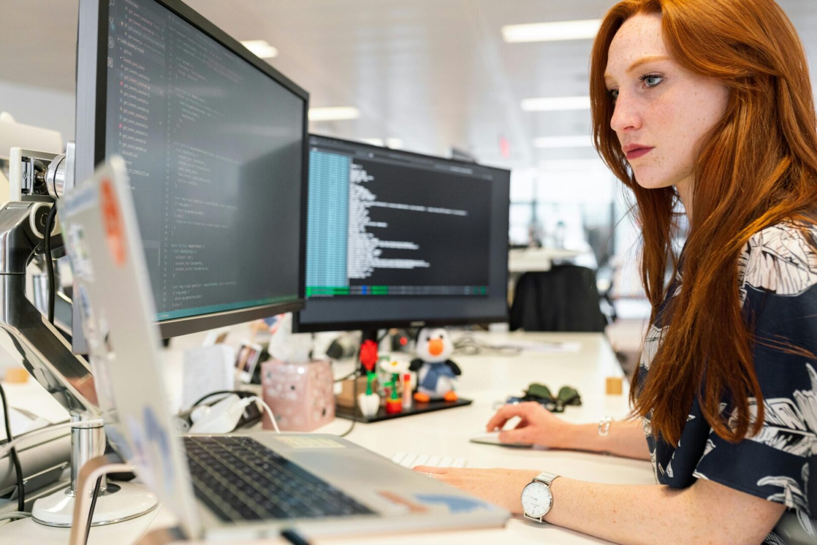 A woman sitting at her desk looking at the computer screen.